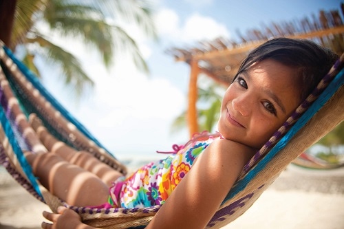 little girl smiling comfortably on a hammock