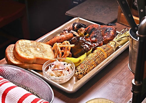 a whole smoker with texas toast, chicken and ribs, and corn on the cob from guy’s pig and anchor smokehouse