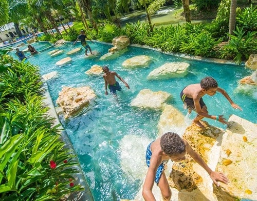children climbing up rocks at a jamaican waterpark