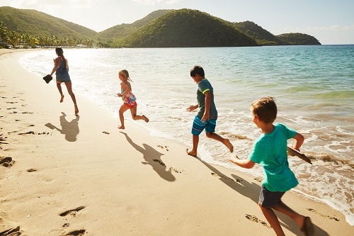children running across the beach in the caribbean