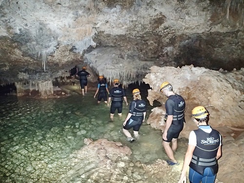 people taking a guided tour into a cavern with a hidden river