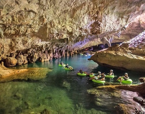 a group of people cave tubing in belize