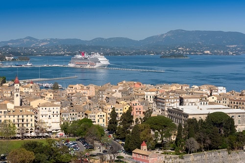 a carnival ship pulling into the port of corfu
