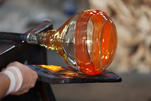 a glassblower from murano, italy, finishing their piece