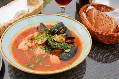 a bowl of seafood soup called bouillabaisse being served in marseille