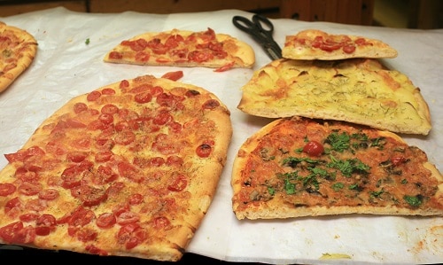 pizza being served by the slice at a pizza restaurant in rome, italy