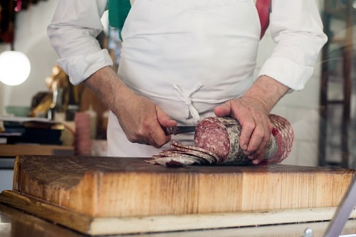 an-italian-butcher-slicing-salami
