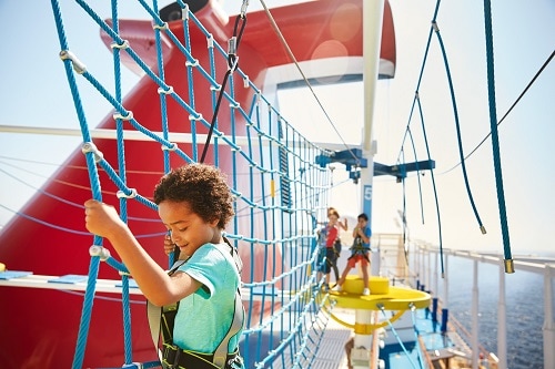 little boy crossing an obstacle on the ropes course