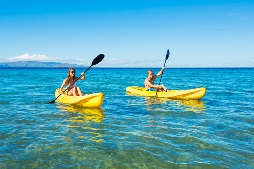 couple kayaking in the ocean on vacation