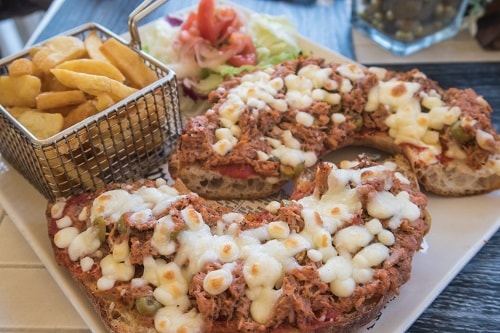 maltese bread, named hobz biz-zejt, topped with tuna, olives, and chesse, served with fries
