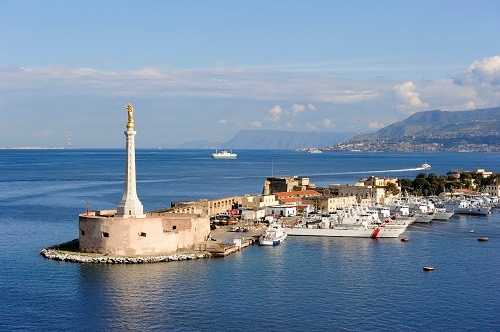 the messina harbor with the gold hail mary statue