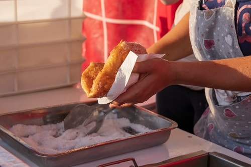 woman preparing fried pizza at a marketplace in italy