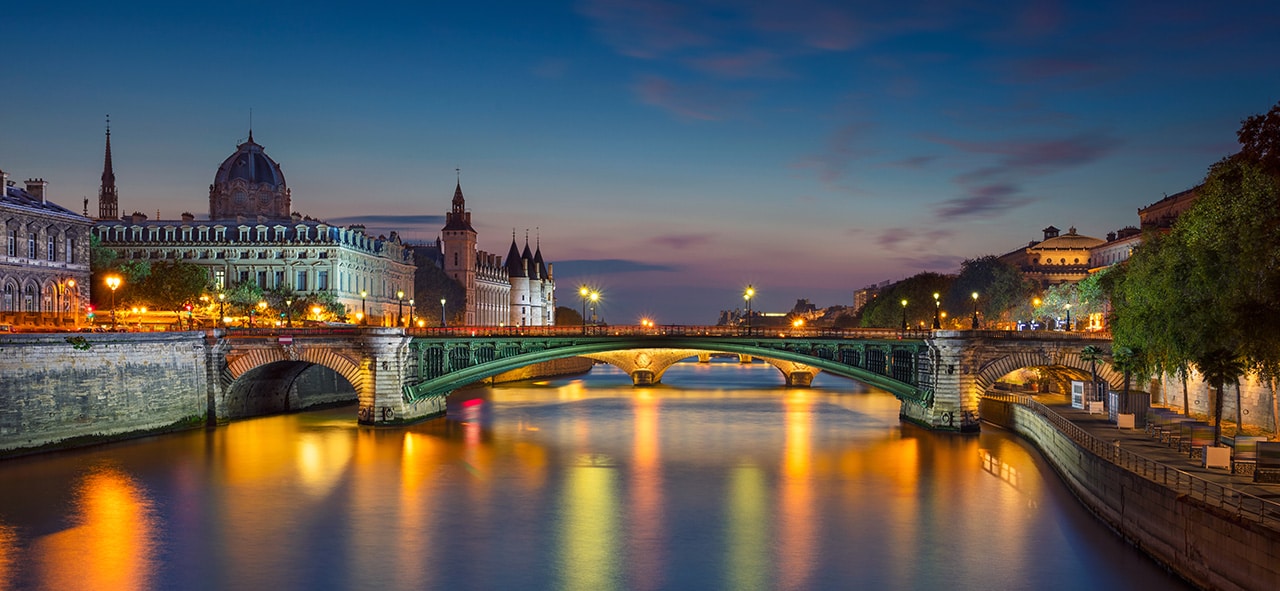 Panoramic image of Paris riverside during twilight blue hour.
