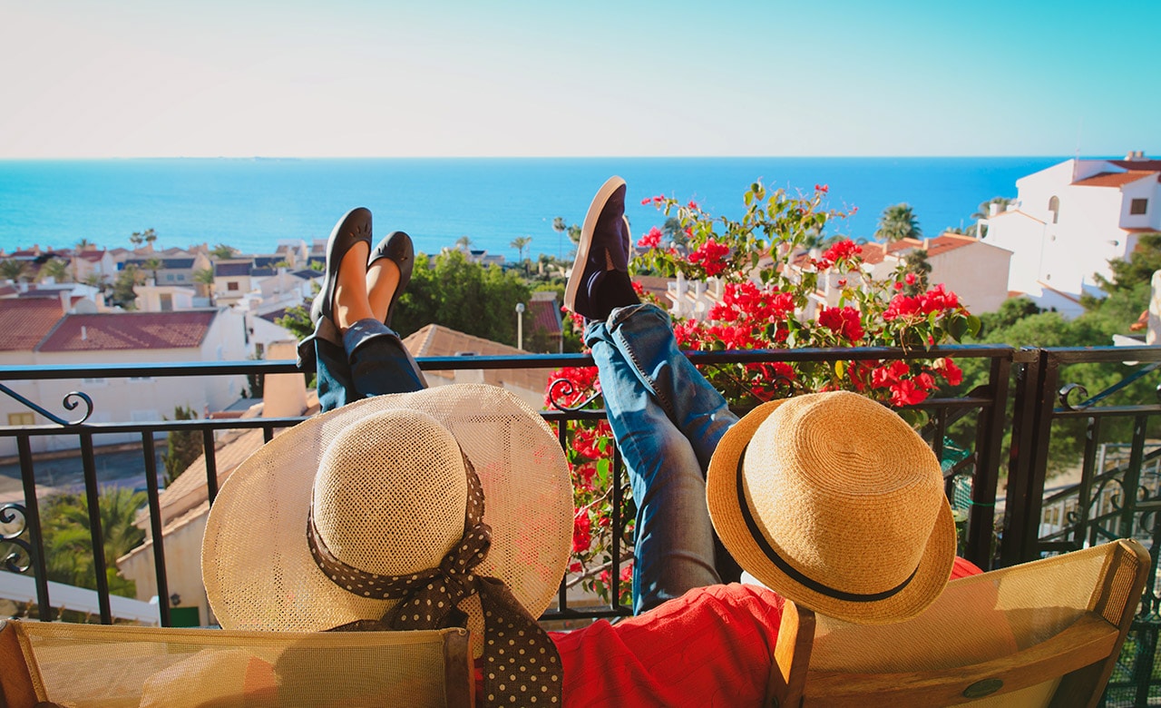 happy couple relax on balcony terrace, on vacation in Europe