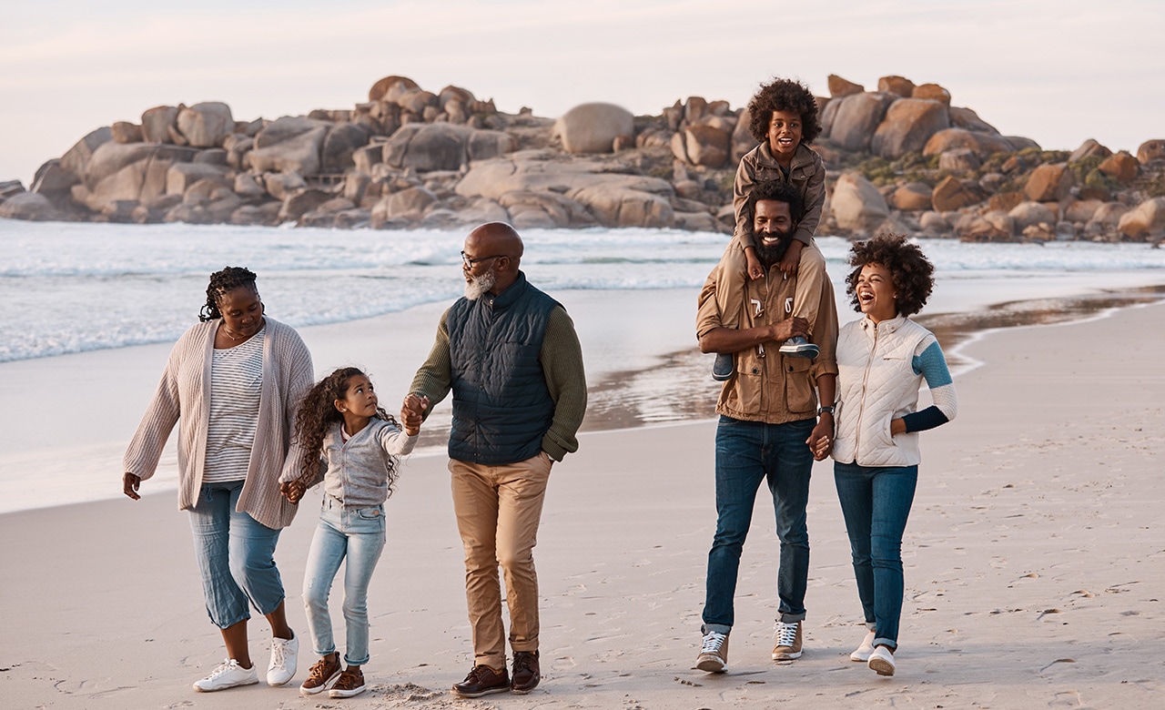 Shot of an adorable little boy and girl having a fun day at the beach with their parents and grandparents