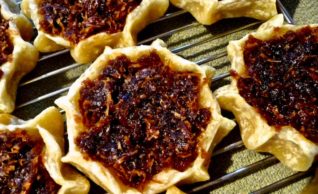 Picture of a tray gizzadas, freshly baked Jamaican pastries.