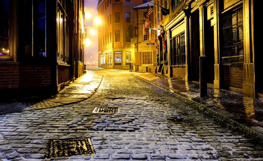 Dimly lit, snow-covered alley in Boston, Massachusetts.