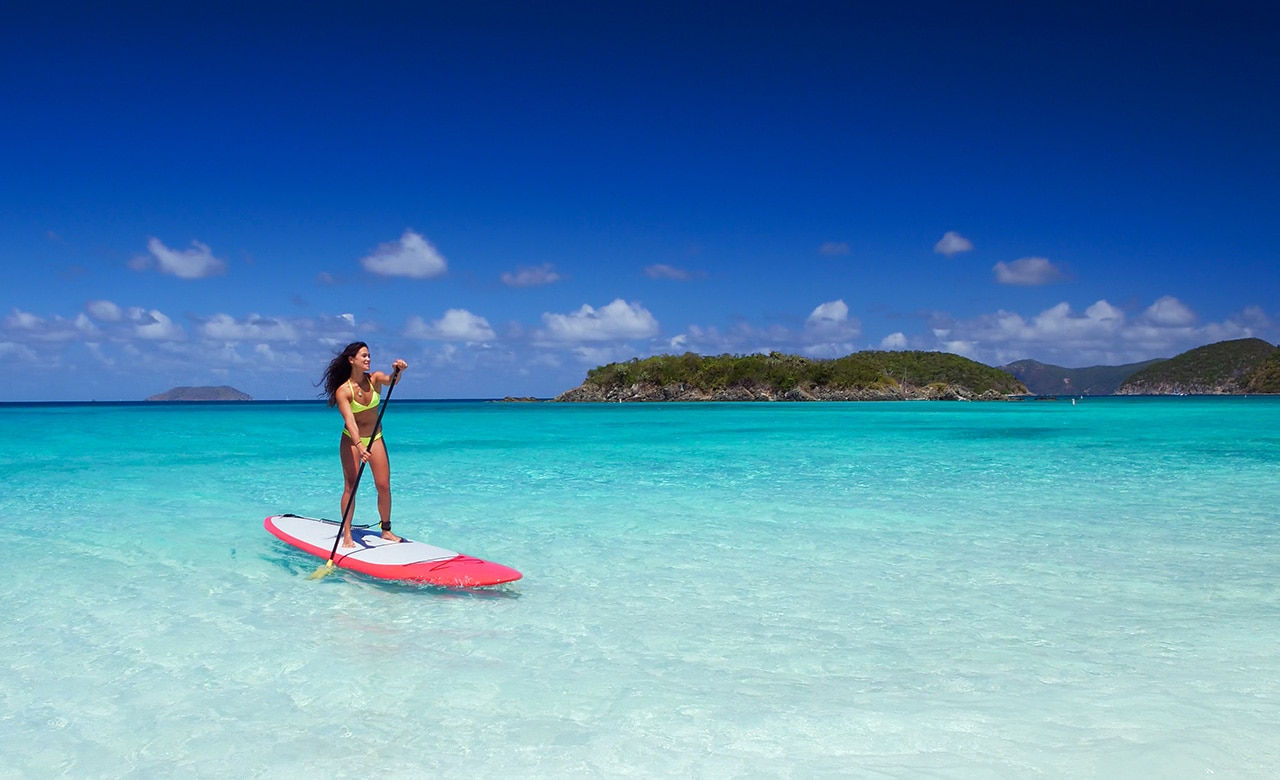 young attractive multi-ethnic woman on paddle board at cinnamon bay, United States Virgin Islands