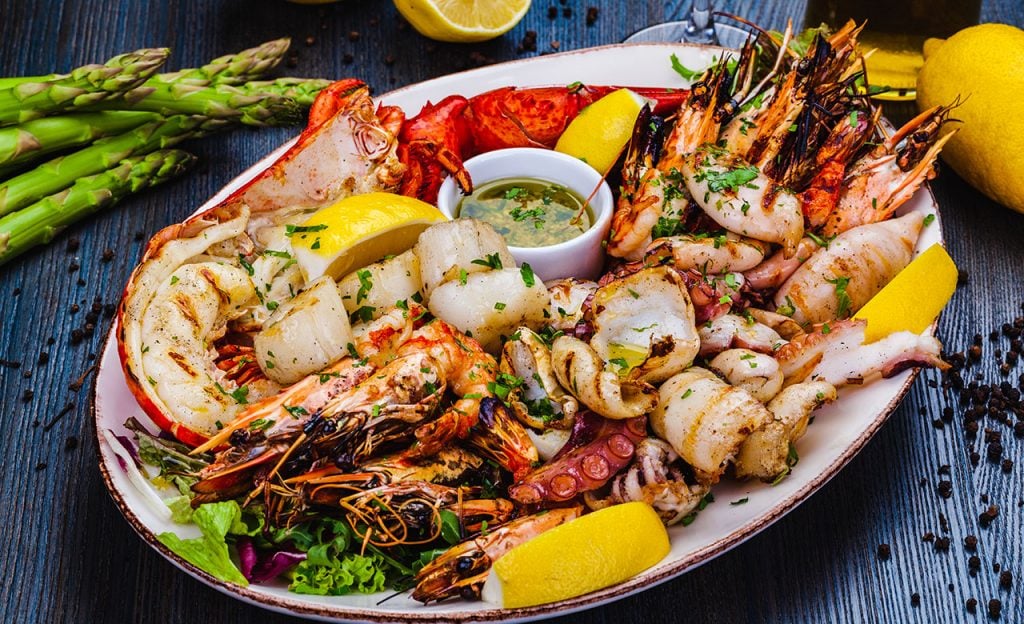 A grilled seafood platter with lobster, prawns, and squid