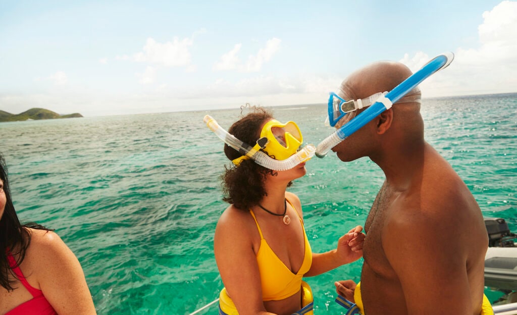 Couple in snorkeling gear by the water