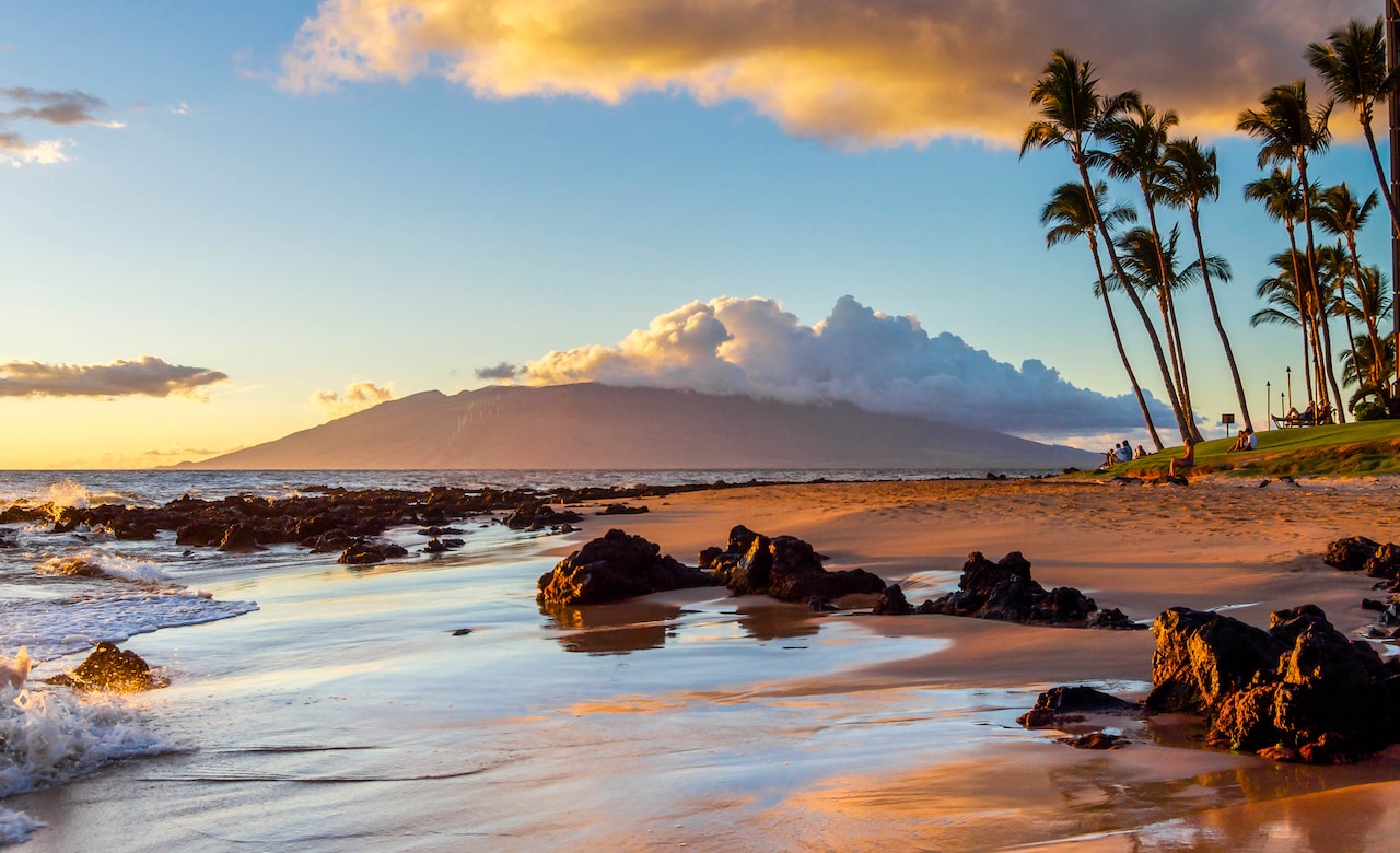 The glow of sunset is reflected on a Maui beach.