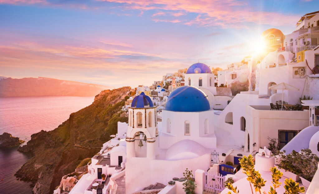 Sunset view of the blue dome churches of Santori, Greece.