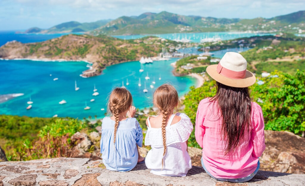 Mother and two daughters overlooking a view of English Harbor from Shirley Heights, Antigua.