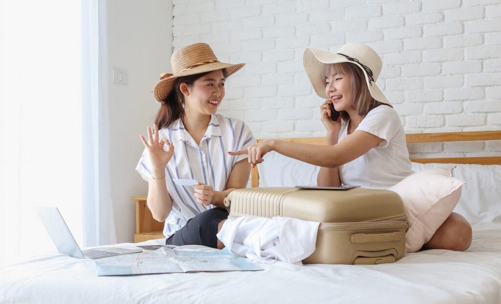 Two women packing luggage.