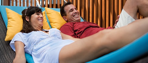 a couple resting on a hammock