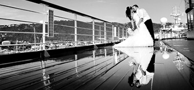 a man and a woman posing for a photo on the deck of a carnival ship after their wedding