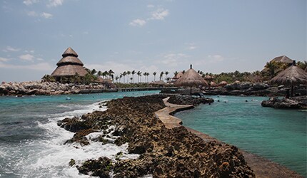 the rocks and tiki huts at the beach in cozumel, mexico