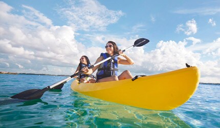 two women kayaking in the bright blue waters of the caribbean