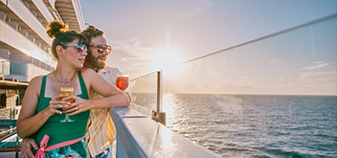 a couple dressed in white hugging on a beach