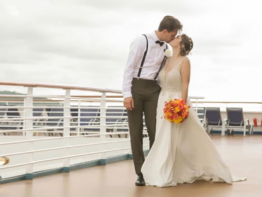 a bride and groom kiss onboard a ship