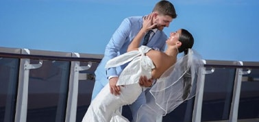 a newlywed couple posing for photos after their wedding on a carnival cruise at sea