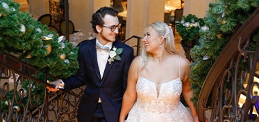 a newlywed couple posing for a photo on the stairs on a carnival cruise